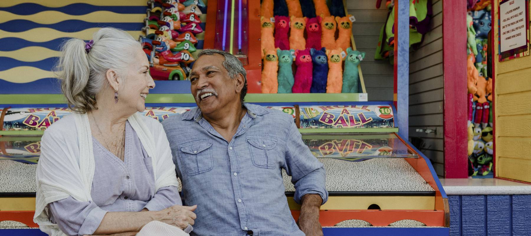 Smiling senior couple resting by a game booth