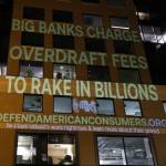 A anti-overdraft-fee graphic projected on a building.