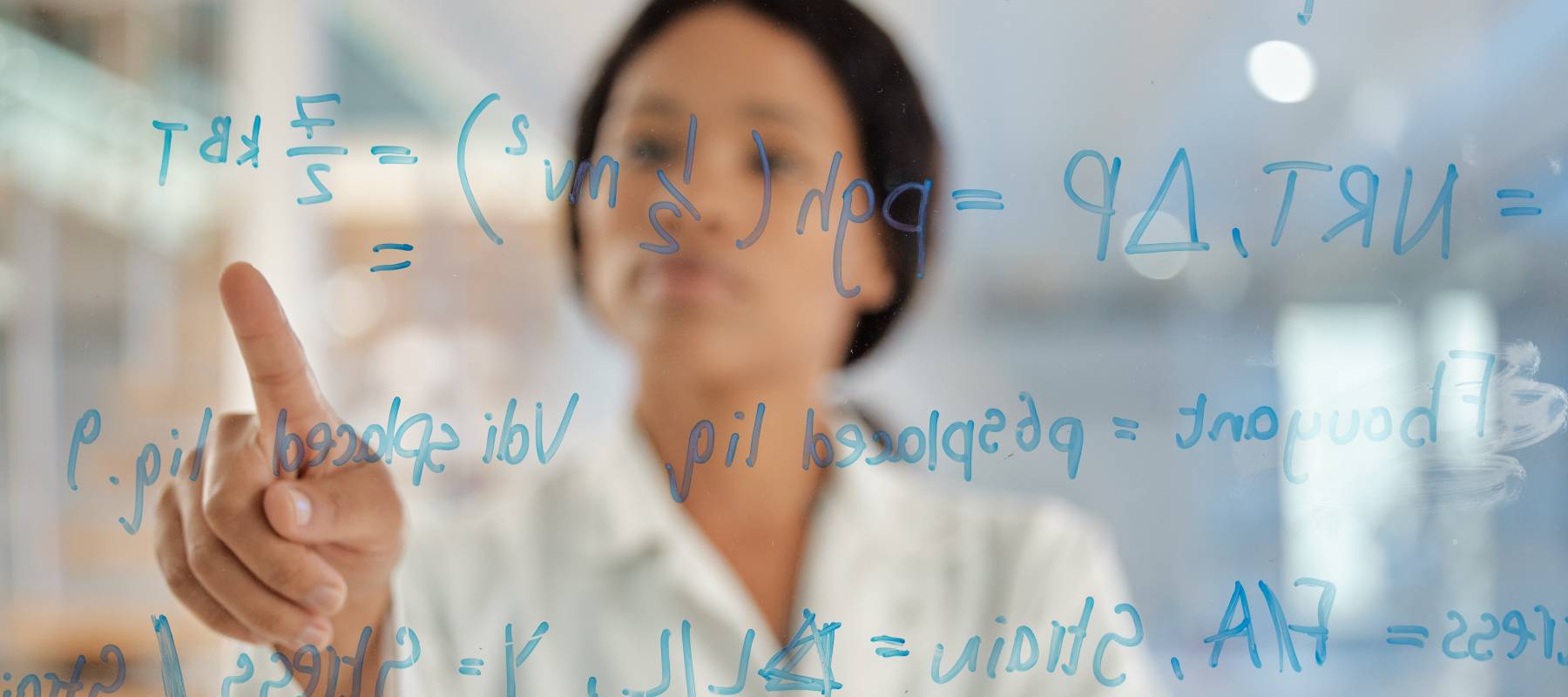 Young scientist looking at formula on a board