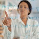Young scientist looking at formula on a board