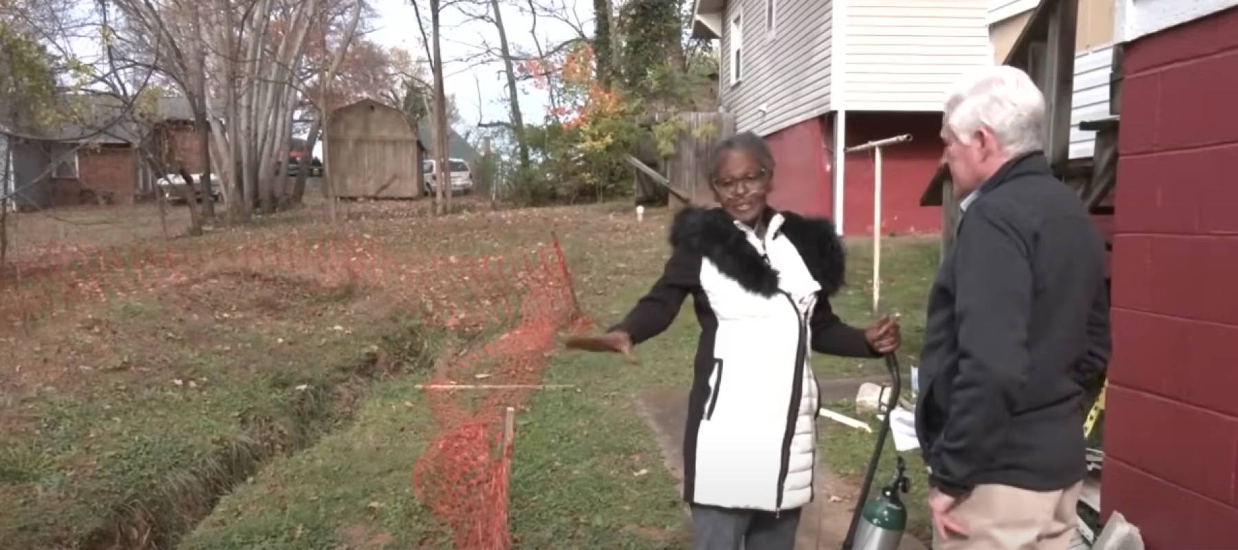 Linda Riddle talking to news reporter about trench