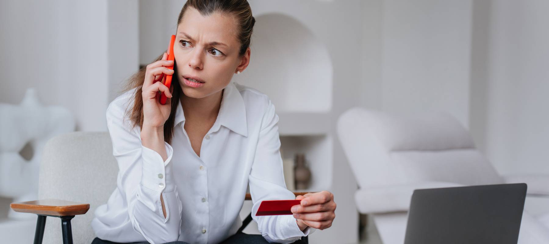Woman talking on phone holding her credit card