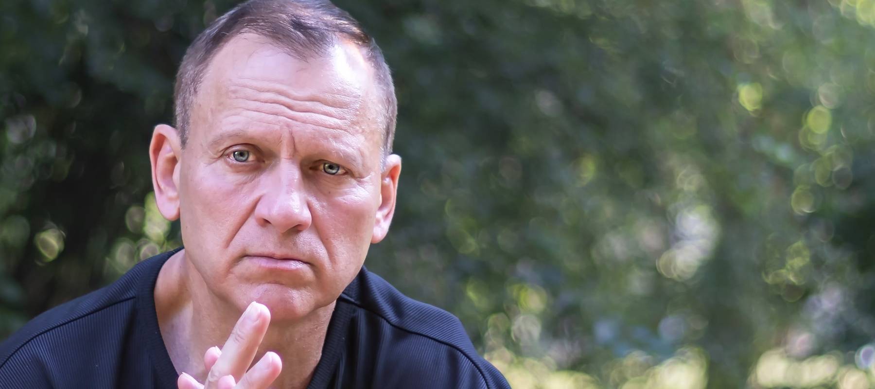 50-year-old man sitting outside looking confused.