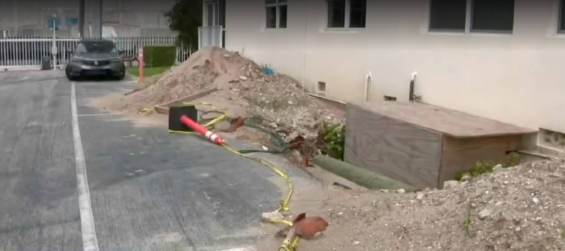 Piles of dirt next to crumbling foundation of building