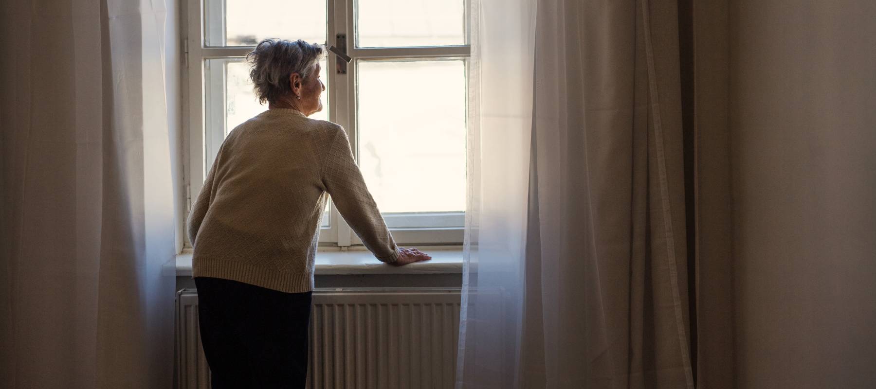 Elderly woman looking out a window