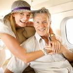 Excited to be headed on holiday. Smiling senior couple on an airplane heading overseas - portrait.