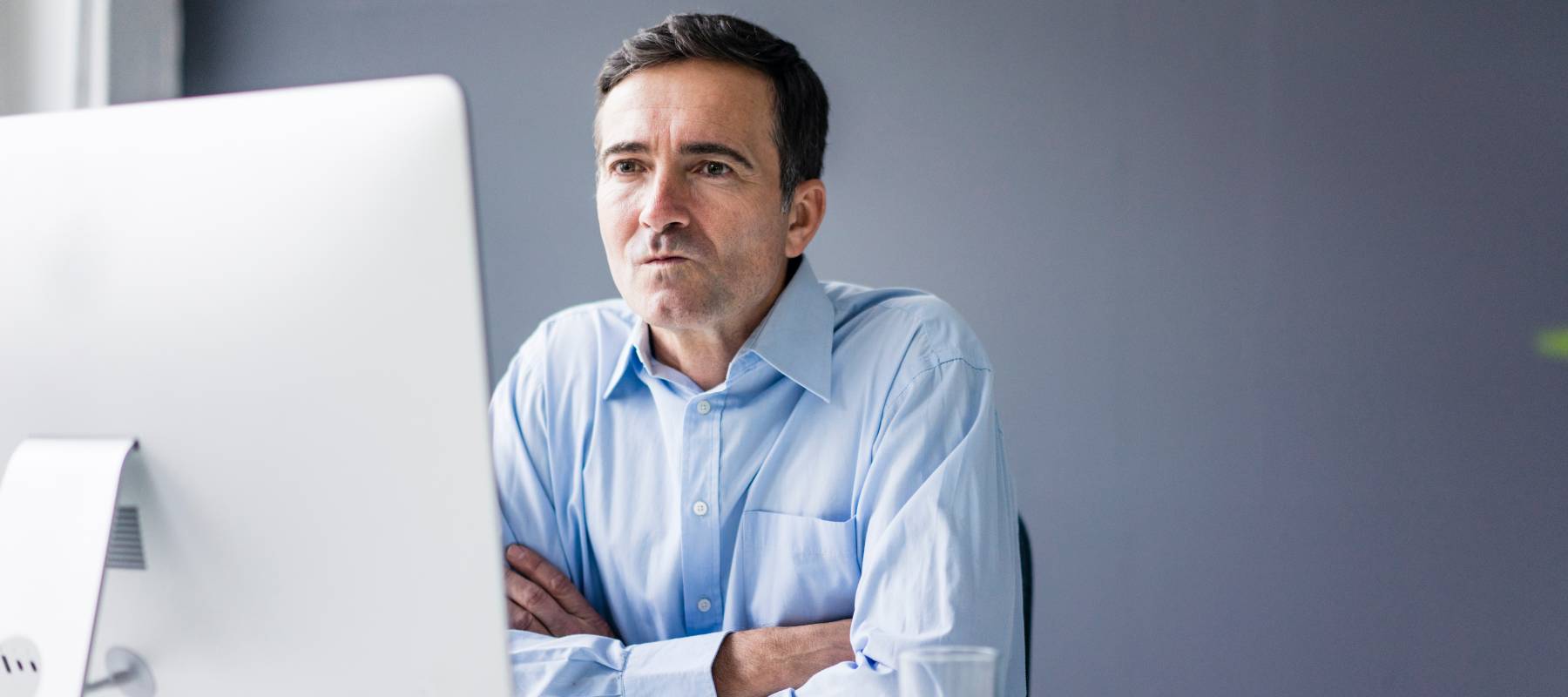 Man sitting at a desk looking at the computer