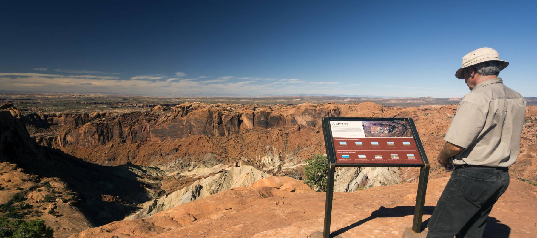 A man reads a points of interest sign in Utah's Canyonlands National Park.