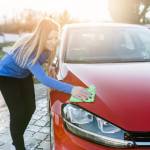 A woman cleans her car.