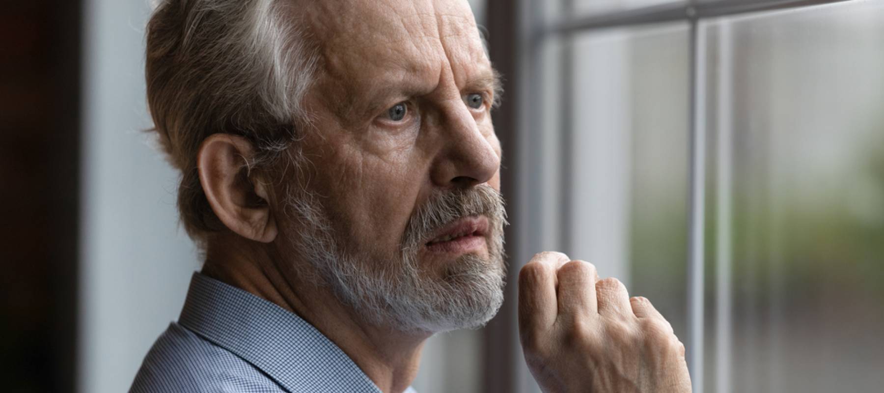 Man looking out of window in regret