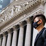 A person wearing a face mask walks past the New York Stock Exchange in New York, New York, USA, 27 January 2020.