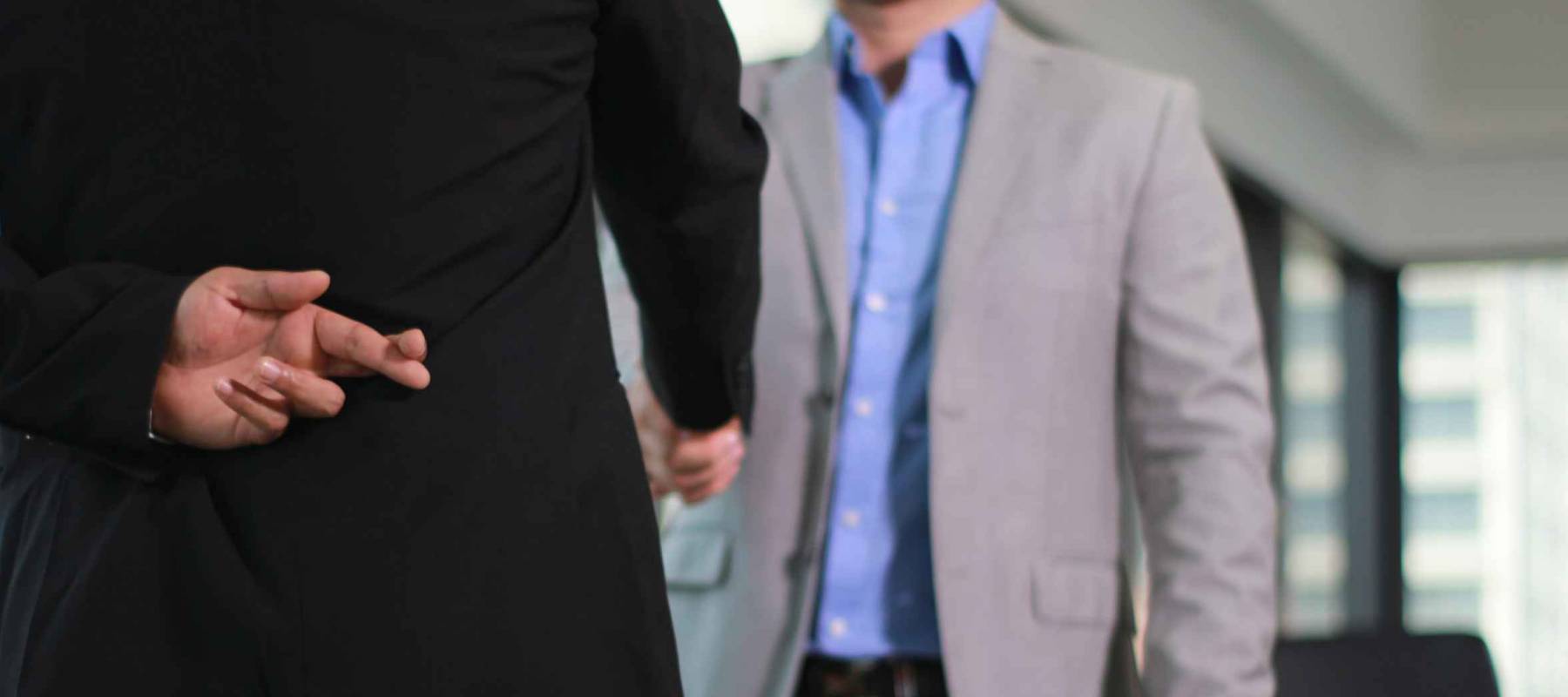 Business man shaking hand with lie sign