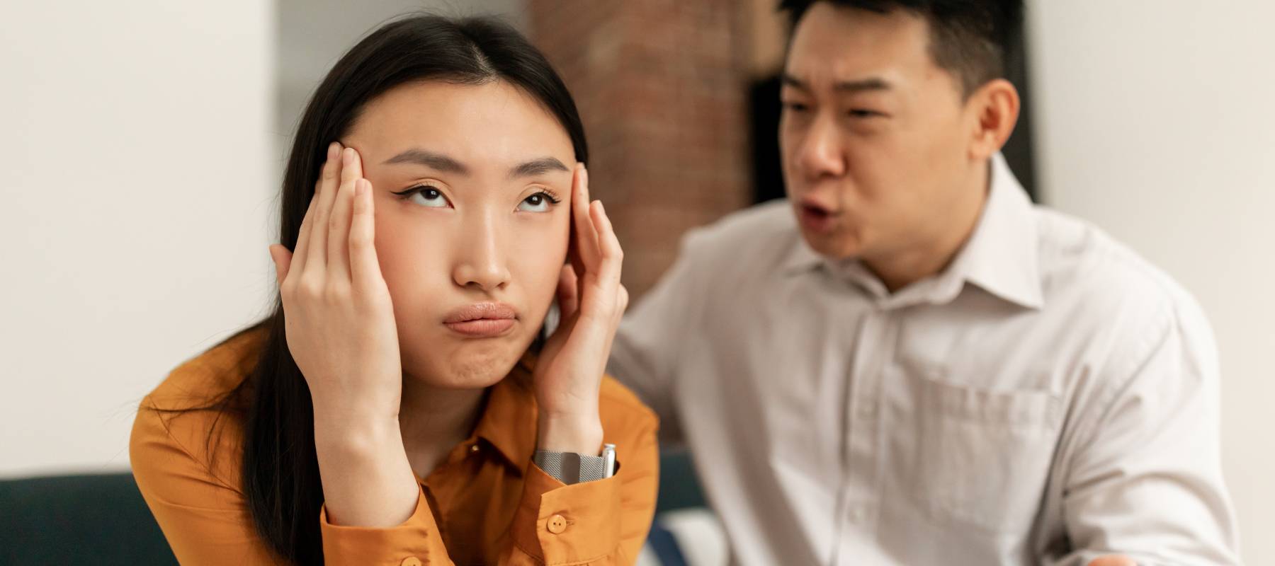 A woman tries to ignore an arguing man.