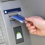 men hand businessman puts credit card into ATM