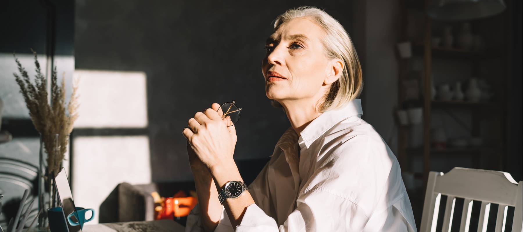 Mature woman reflecting at her desk