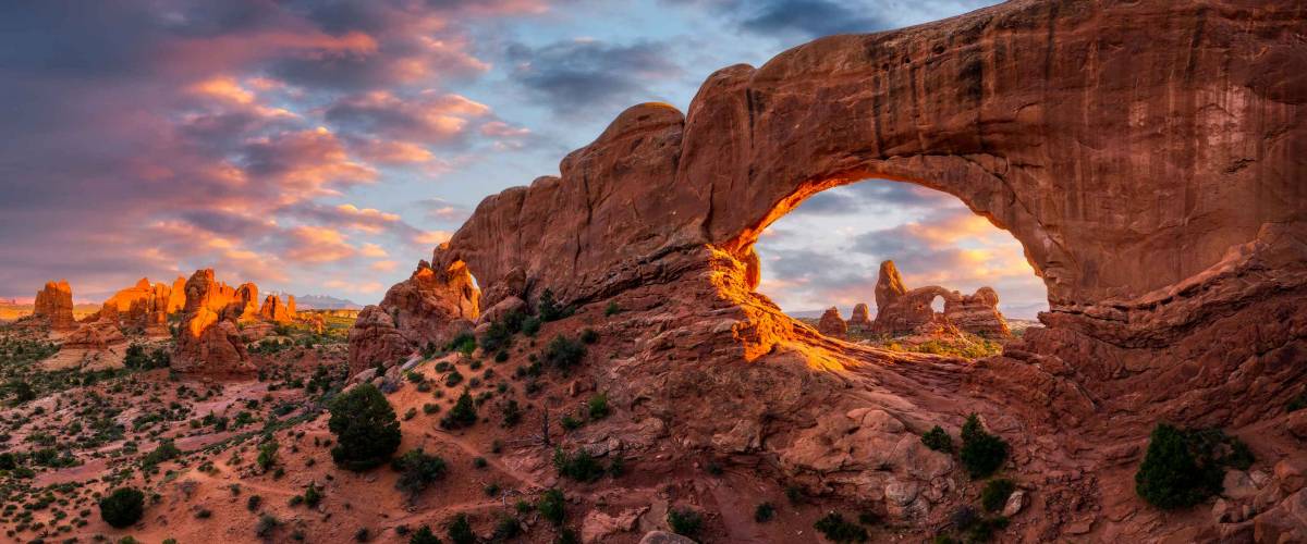 Luz de la tarde sobre la ventana norte con arco de torreta en la distancia, el Parque Nacional Arches, Utah