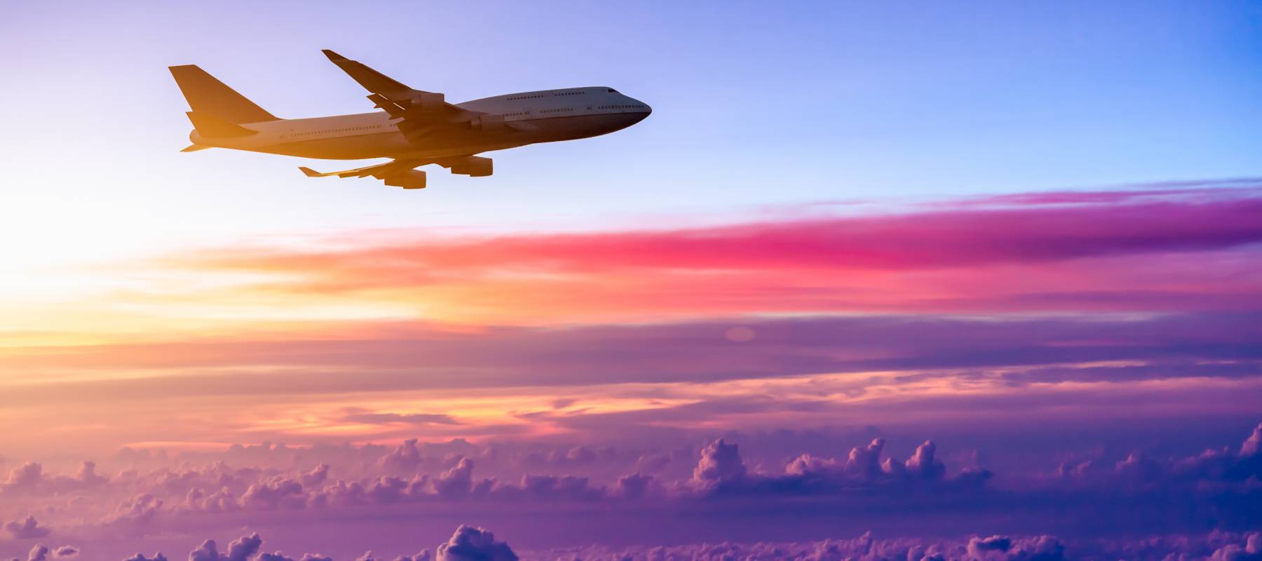 Airplane flying with clouds in the background.