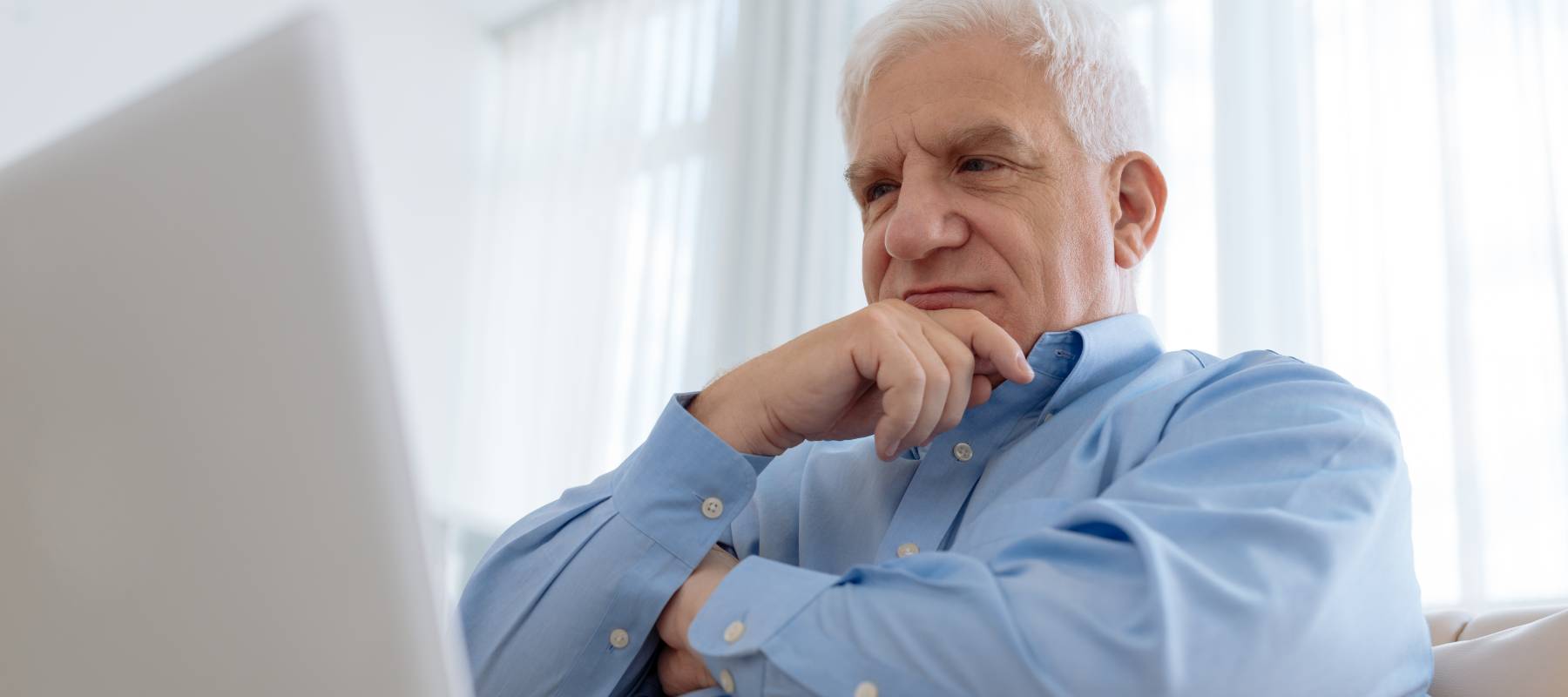 Man looking at a computer and thinking