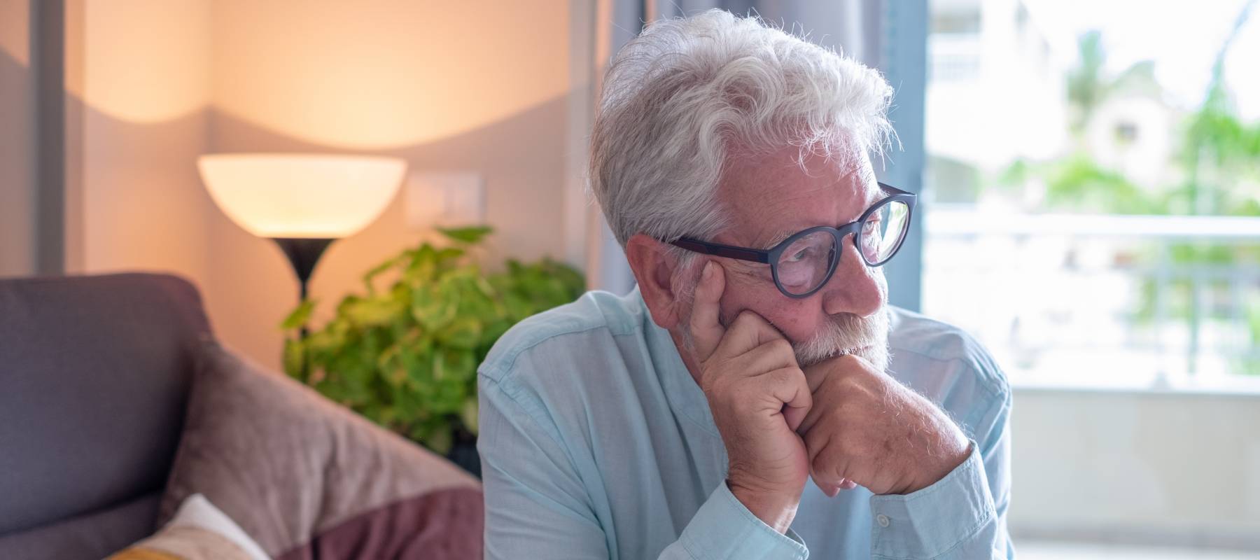 Older man thinking in a living room