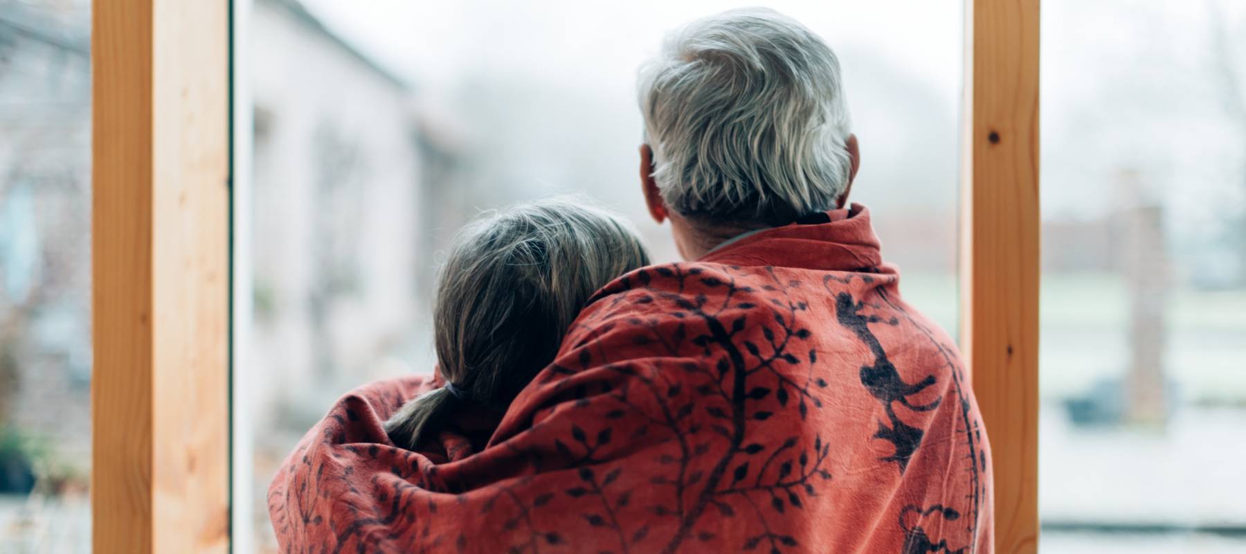 Elderly couple looking out a window