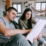 A young couple looking at paperwork in a house
