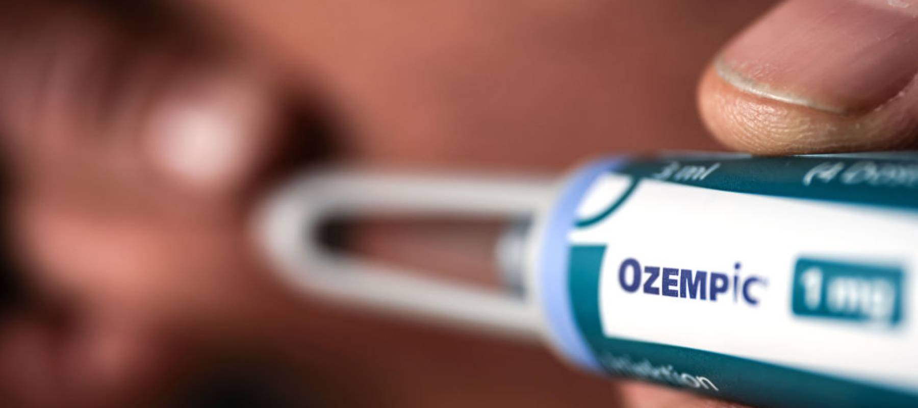 A man uses an Ozempic drug syringe.