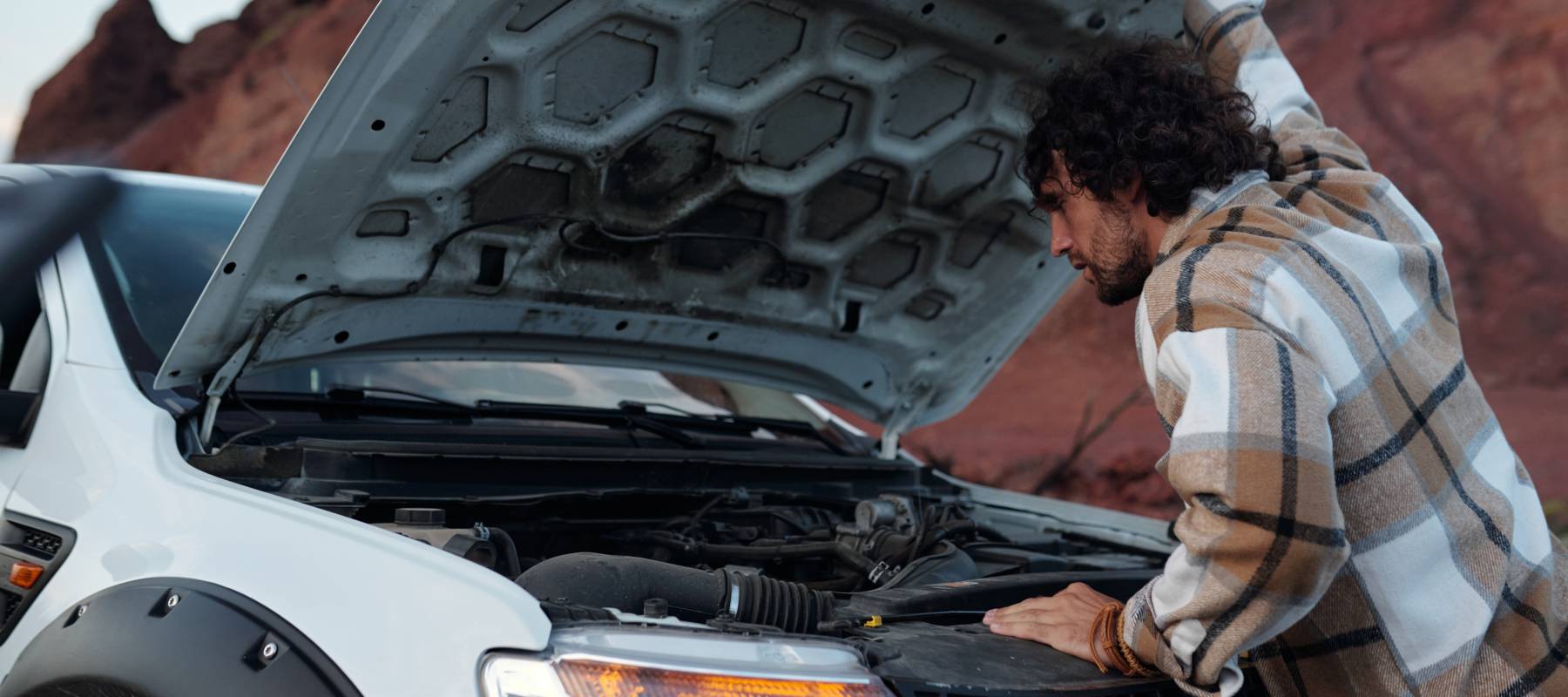 Man looking under the hood of a truck