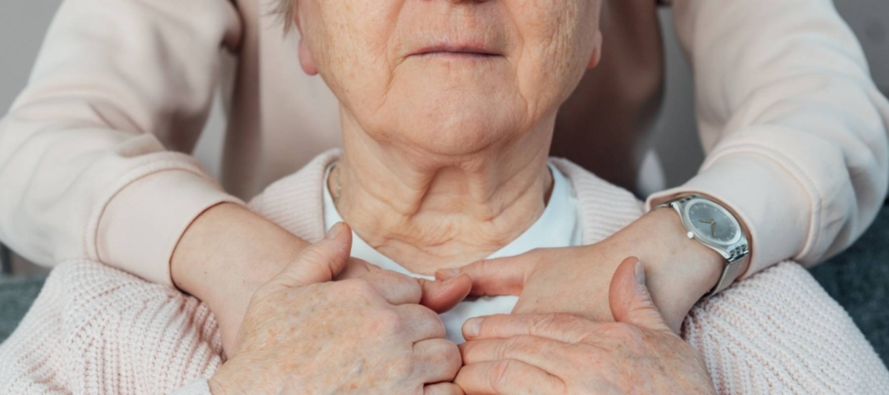 Senior smiling woman feeling young relative's or caregiver supportive touch