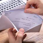 Hands opening paycheck