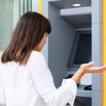 Seemingly annoyed woman at a bank ATM.