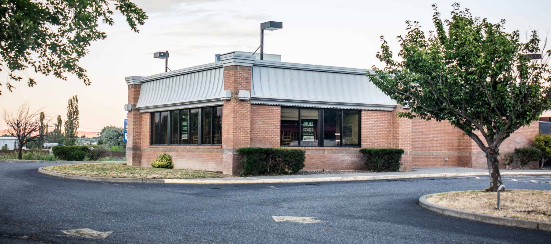 JULY 14 2017 - THE DALLES, OREGON: An abandoned fast food restaurant sits for sale in Central Oregon on a summer day.