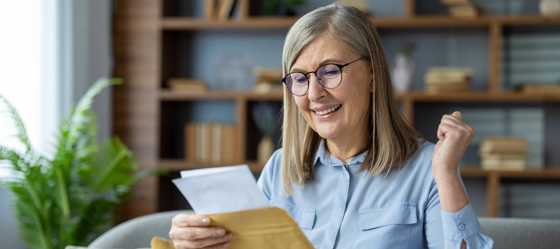 A woman rejoices after receiving good news in the mail.