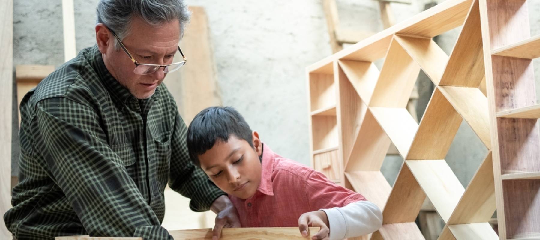 Older man teaching young man carpentry.