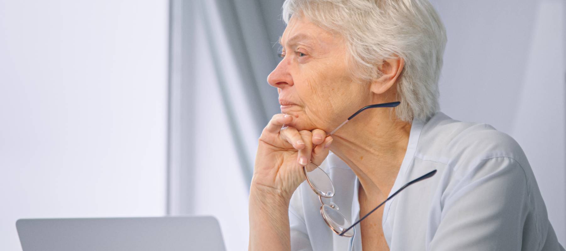 Elderly woman at the computer thinking