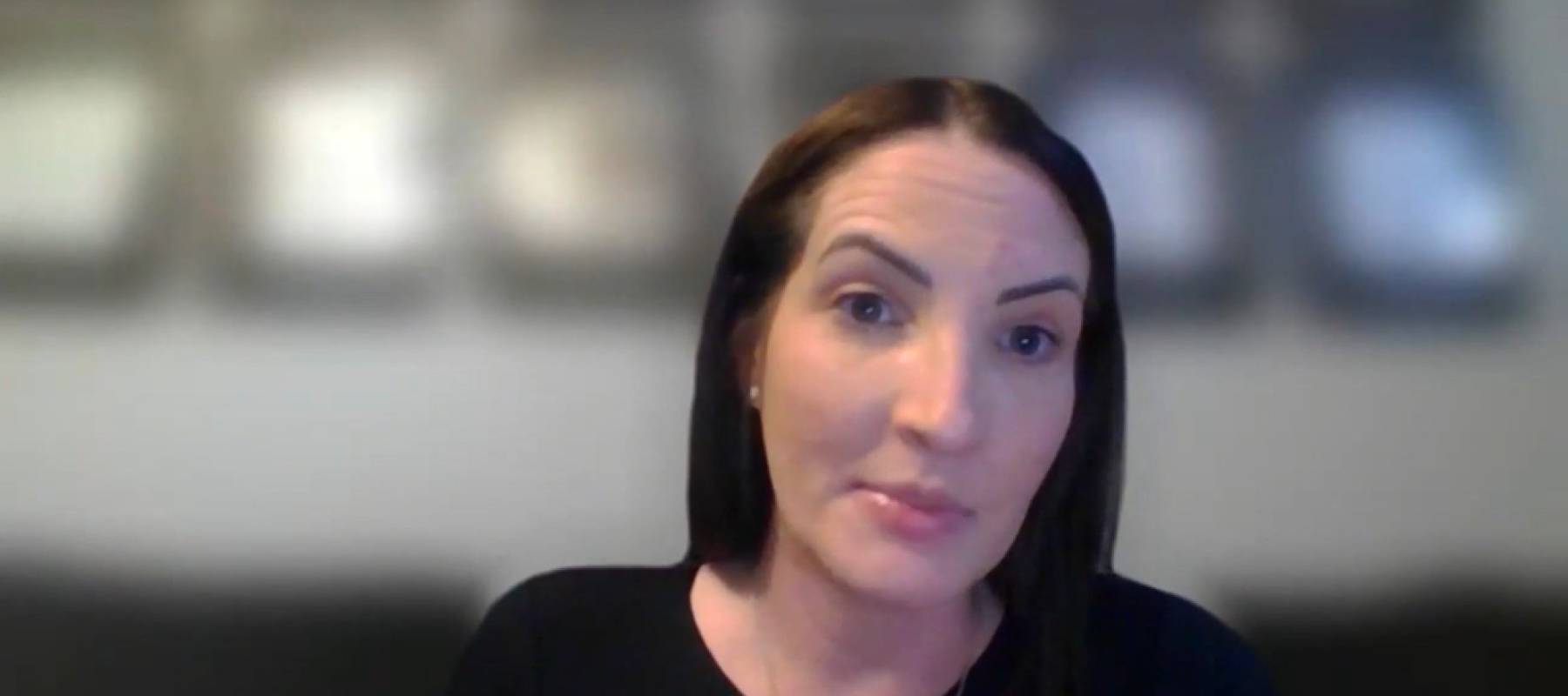 Woman seen doing video interview at home, speaking with eyebrows raised.