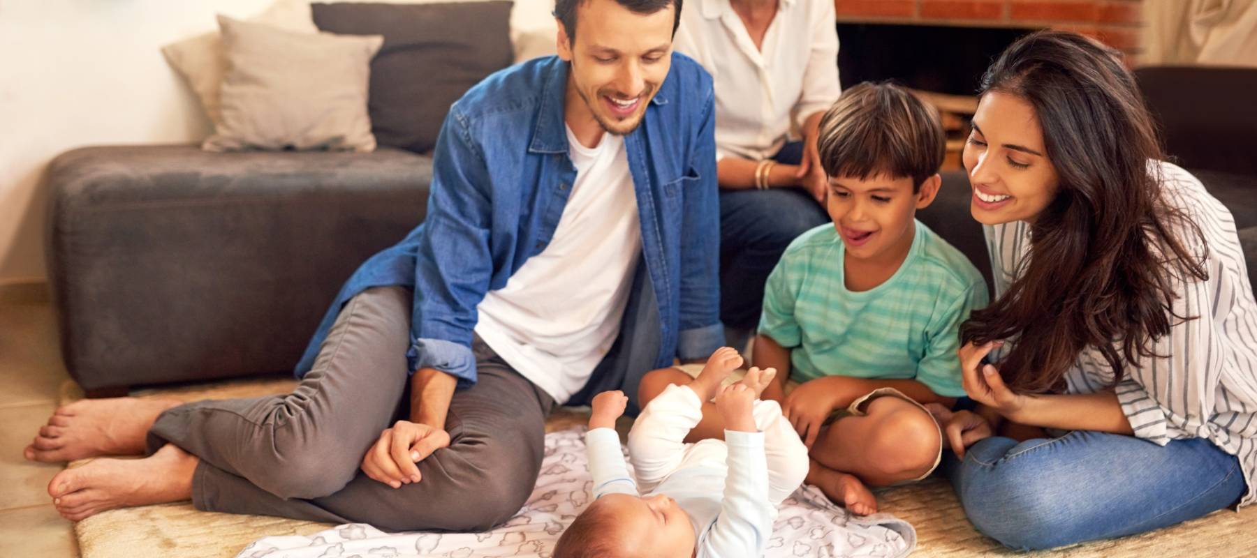 Family looking at a new baby in a house