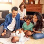 Family looking at a new baby in a house