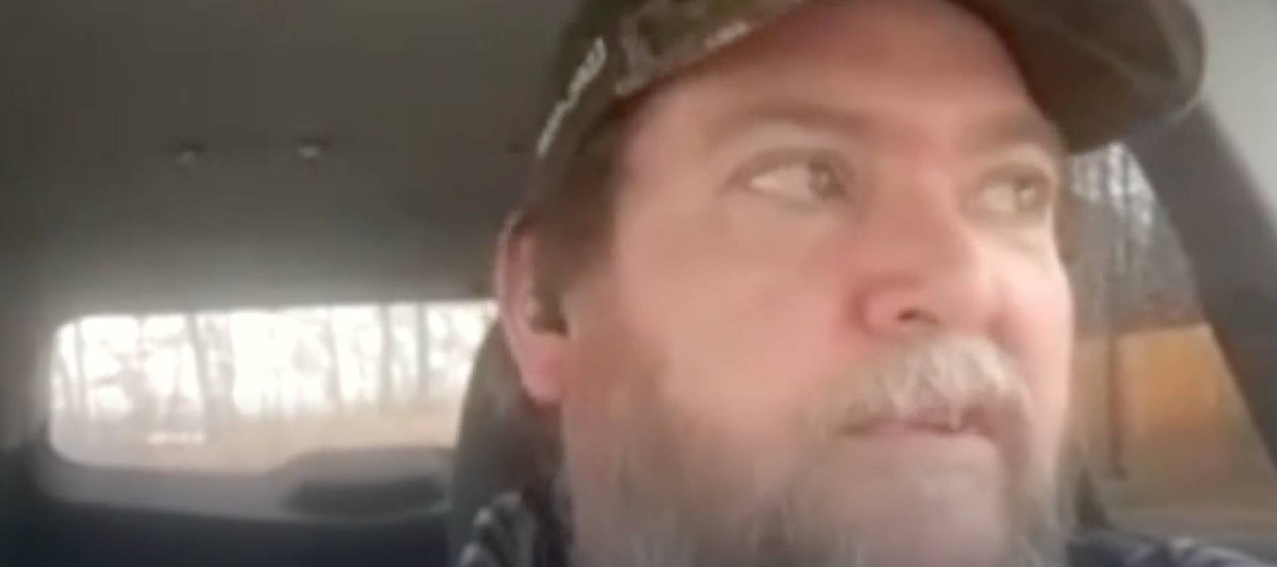 Man looks out car window.