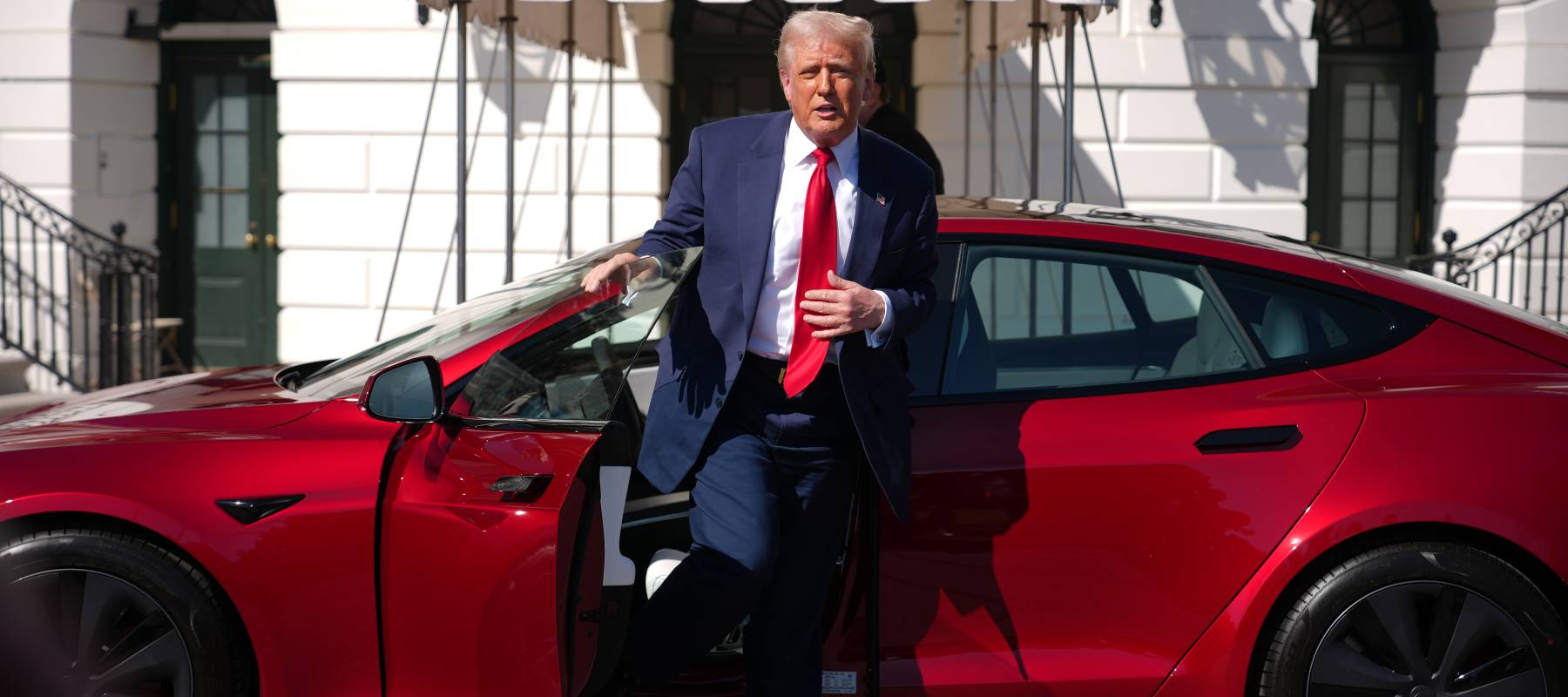 Donald Trump exiting a Tesla car.