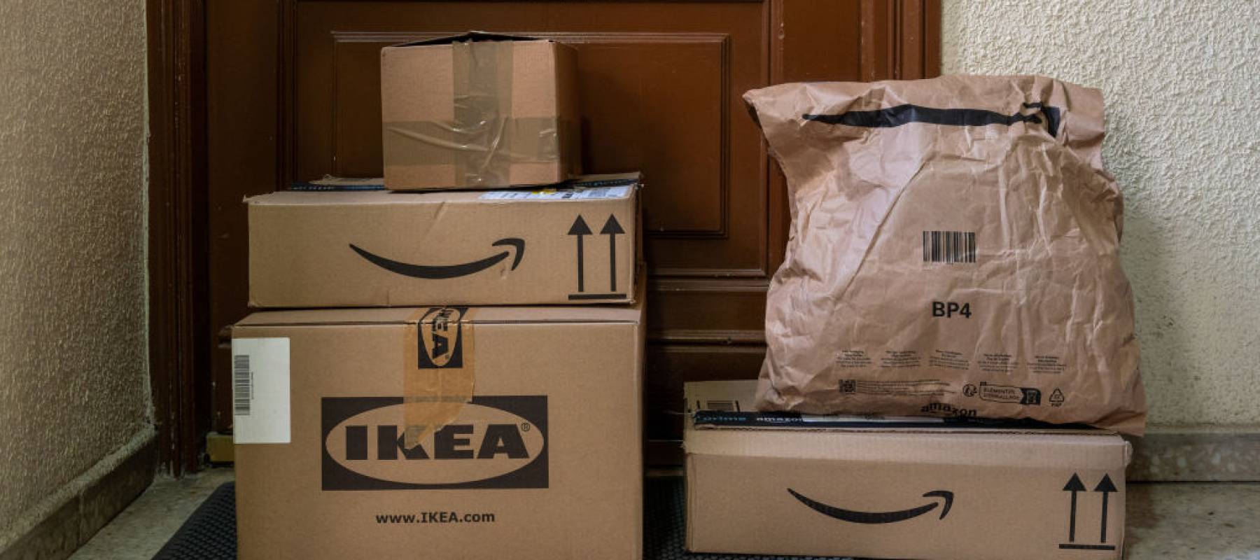 Amazon and Ikea delivery packages stacked at a front door.