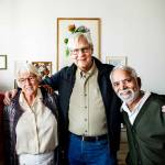 Group of senior friends posing with arms around each other.