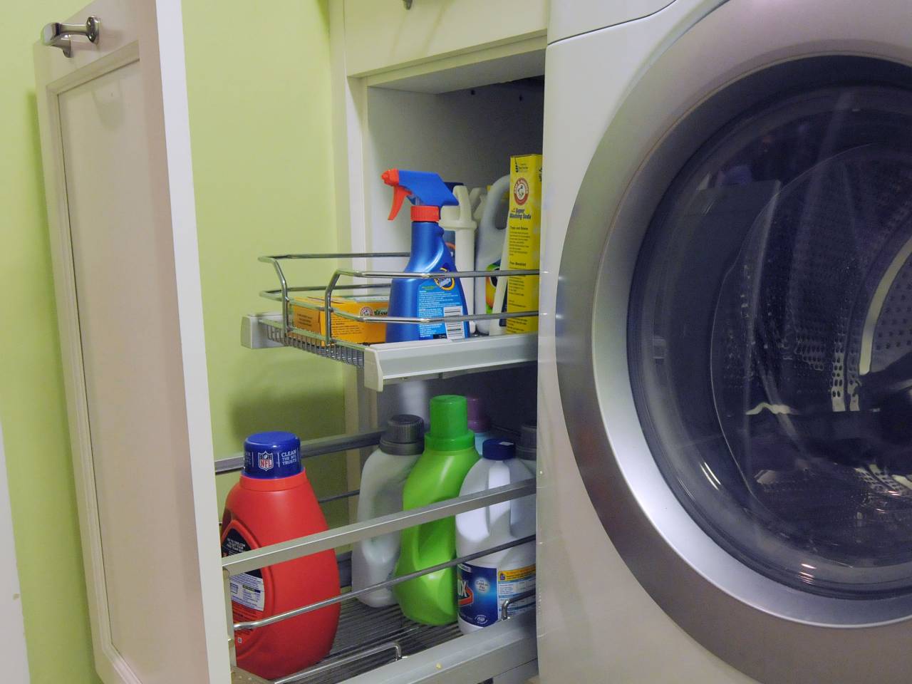 Laundry room drawer with cleaning supplies.