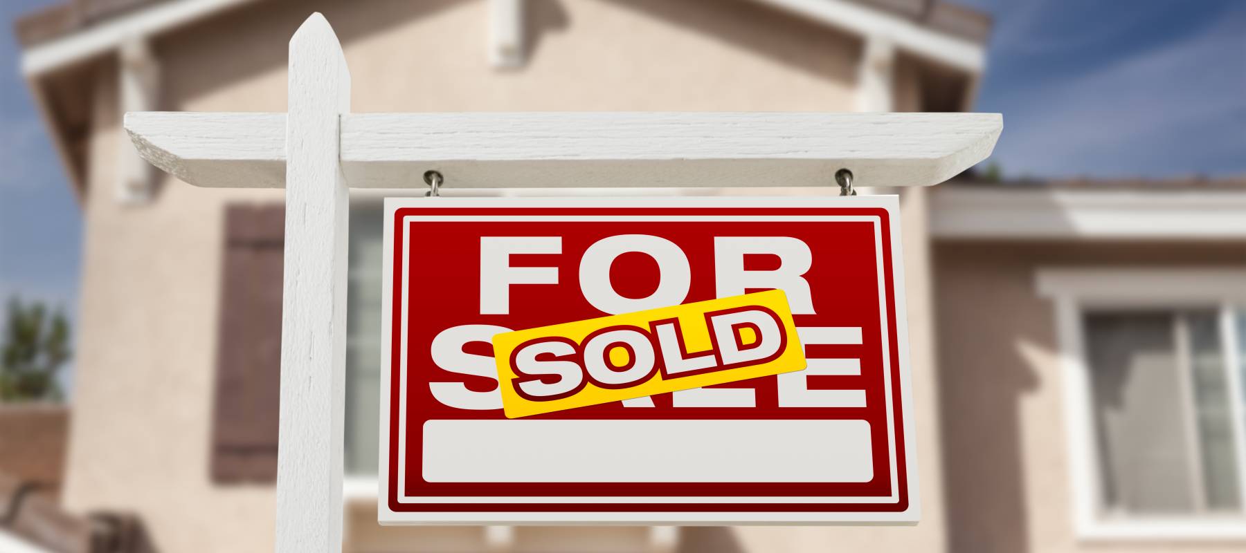 For Sale sign with a Sold sticker on it