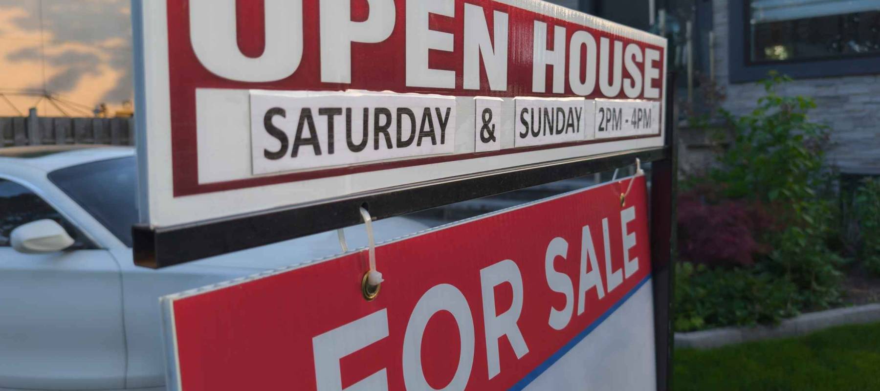Sign for sale open house in front of detached house in residential area. Real estate bubble, crash, hot housing market, overpriced property, buyer activity concept.