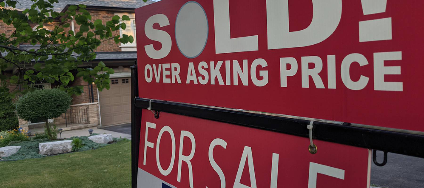 New sign sold over asking price for sale in front of detached hous