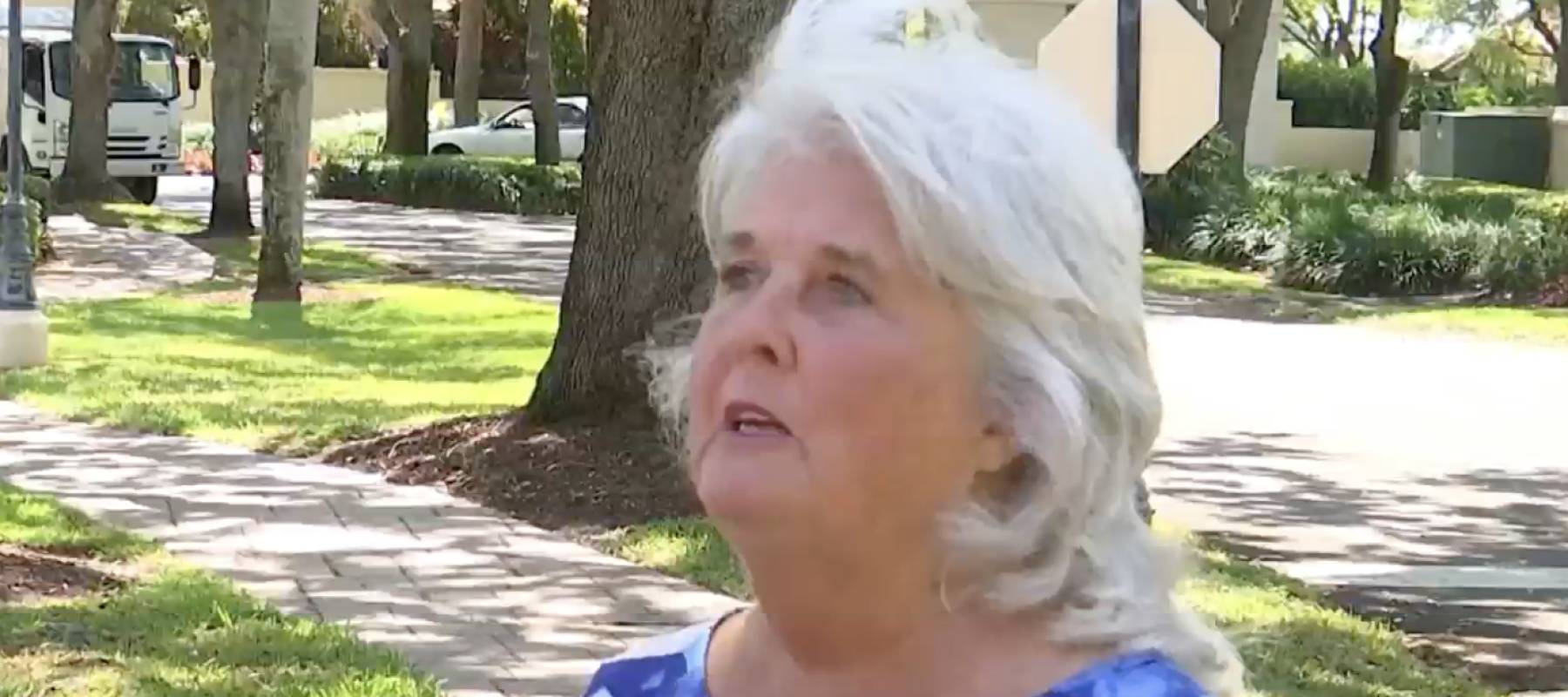 Woman being interviewed by reporter, standing on Florida street.