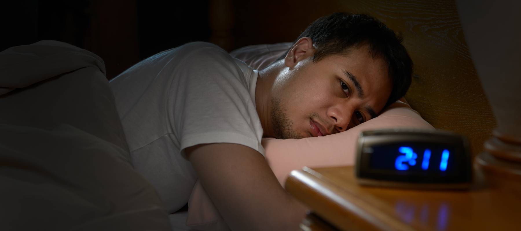 Man lying in bed, can't sleep