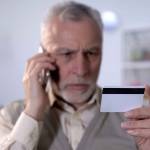 Old man holds credit card