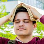Young man covers his head with a book