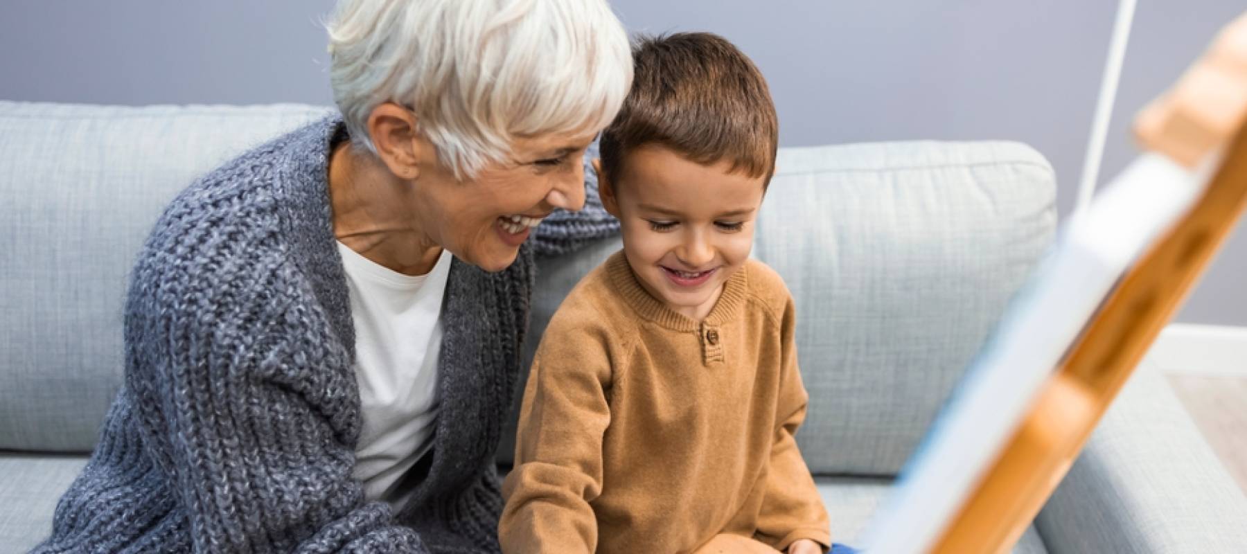 Senior Woman helps young boy paint.
